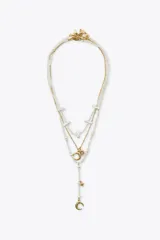 Set de tres collares de diferentes largos. Uno de perlas de diferentes tamaños con cierre de mosquetón. Otro de eslabones metálicos dorados con colgantes en forma de sol y luna. El tercero de perlas de diferentes tamaños con colgantes metálicos dorados en forma de luna labrada y estrella.