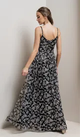 Vestido largo de fiesta negro con breteles finos y escote en V. El vestido es de tul bordado con flores y lentejuelas plateadas.