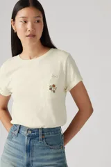 Remera color crema de corte recto, con mangas cortas con dobladillo y bolsillo en el pecho con bordado floral.