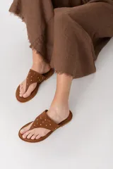 Sandalias de cuero color marrón con apliques de tachas doradas.