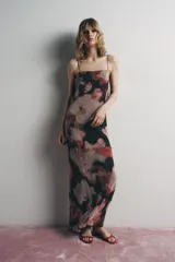 Vestido largo con estampado floral en tonos rosa, rojo y negro. Escote redondo con tirantes finos ajustables, espalda pronunciada y tira cruzada ajustable con lazada. Detalle de abalorios a contraste y forro interior.