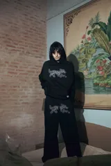 Pantalón negro de felpa de algodón, corte oversize, con doble cintura simulando bóxer y estampa de alta calidad.