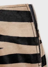 Minifalda de piel bovina con estampado animal print de cebra, tiro medio y cierre lateral con cremallera.