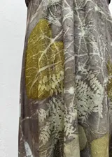 Vestido largo con estampado de hojas en tonos verdes y marrones.