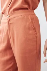 Pantalón celeste de lino, corte recto, con efecto desflecado en el ruedo.