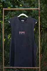 Musculosa sin mangas, color negro con efecto acid wash, con un pequeño estampado frontal de tres hongos estilizados en tonos naranja y blanco.
