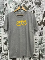 Remera gris con estampado amarillo de la palabra "OPPAI" con un diseño que simula senos.
