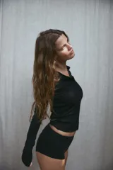 Camiseta negra de manga larga con cuello redondo y cierre frontal con botones.