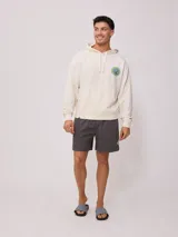 Canguro con capucha color crema, con bolsillo tipo canguro, puños y cintura acanalados. Estampado en el pecho con el logo de la marca y un diseño de sol.