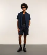 Bermuda masculina color beige confeccionada en sarga, de corte recto, con cintura con trabilla, cierre tradicional y bolsillos laterales y traseros.