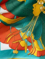 Pañuelo cuadrado de satén estampado con diseño floral en tonos naranja, celeste y lila.