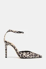 Zapato destalonado con estampado animal, taco fino alto y punta fina. Cierre mediante tira con hebilla a la pulsera del tobillo.