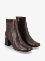 Botín de cuero color marrón oscuro con tacón cuadrado y cierre lateral.