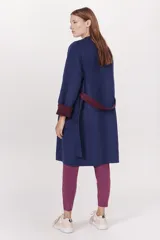 Tapado azul marino con cuello en V, mangas largas con puños en color borgoña y cinturón de lazo borgoña.