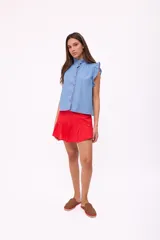 Falda corta de lino color rojo, con diseño de tiro alto y un volado en el ruedo. Posee cierre en la parte posterior.