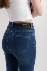 Pantalón de jean azul oscuro, de corte acampanado y tiro alto.