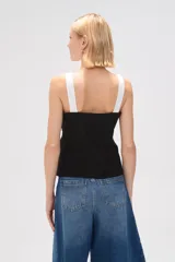Top negro con breteles anchos, escote recto, cierre frontal con botones y bolsillos tipo parche.