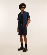 Bermuda masculina color beige confeccionada en sarga, de corte recto, con cintura con trabilla, cierre tradicional y bolsillos laterales y traseros.