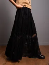 Pollera larga de encaje negro con volados y volumen en el bajo.