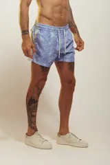 Short de baño celeste con estampado de personas nadando y faroles.