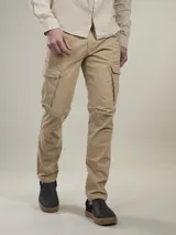 Pantalón cargo color beige confeccionado en sarga de algodón con spandex. Diseño funcional con múltiples bolsillos y corte ajustado.
