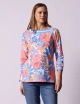 Blusa de algodón con estampado de flores en tonos rosa, naranja, azul y blanco. Tiene cuello cuadrado con borde celeste y mangas 3/4 con borde celeste.
