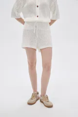 Short color marfil de tejido de punto calado con cintura elastizada y cordón ajustable.