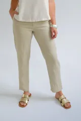 Pantalón color beige de corte recto y largo a la altura del tobillo.