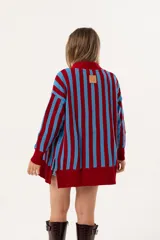 Cárdigan tejido a rayas rojas y celestes, de corte oversize y escote en V.