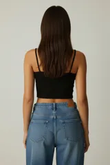 Musculosa blanca de algodón con breteles finos y estampado de una frutilla en el pecho. Corte al cuerpo.