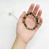 Pulsera elástica con cuentas de ágata india de 8 mm de diámetro y separador de acero hipoalergénico.