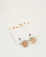 Aros de acero plateado con forma de argolla, con dije circular color beige con borde de strass.