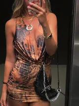 Vestido corto ajustado al cuerpo, con estampado animal print en tonos marrones y negros. Tiene escote en V pronunciado y breteles finos.
