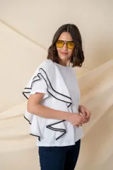 Blusa blanca de algodón con volado en un costado y vivo negro.