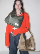 Cartera tipo baguette negra de lona semi impermeable con cierre metálico y forrería de gross con bolsillo interno.