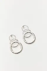 Par de aros colgantes plateados con tres círculos texturizados de diferentes tamaños.