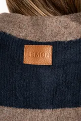 Sweater de tejido de punto grueso, color marrón y azul marino, con diseño de rayas horizontales anchas. Presenta cuello polo y abertura frontal con dos botones nacarados.