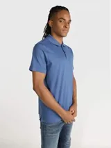 Chomba de piqué azul con cuello clásico, tapeta de dos botones y mangas cortas. Logo de Calvin Klein bordado en el pecho.