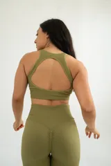 Top deportivo gris con breteles anchos y espalda deportiva.