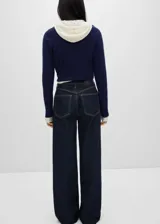 Pantalón de jean azul oscuro, corte wide leg, tiro alto, con cinco bolsillos, trabillas y cierre frontal con cremallera y botón.