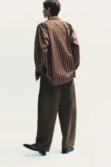 Pantalón cargo negro de corte amplio con cintura ajustable con cordón, bolsillos laterales y bolsillos tipo parche en las piernas.