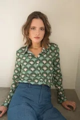 Camisa de manga larga con cuello camisero y botones frontales. Estampado con motivos geométricos en tonos verde, celeste y beige.