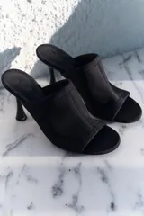 Sandalias negras con punta redonda y tira ancha en tejido elástico en el empeine. Taco de carrete.