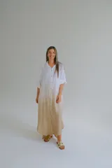 Vestido camisero largo color blanco con degradé a beige, de lino italiano, con cuello camisero, manga 3/4 con botón ajustable y cierre frontal con botones.