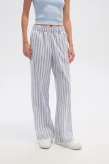 Pantalón de algodón a rayas verticales celestes y blancas, de corte holgado y tiro alto.