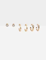 Set de tres pares de aros dorados: un par de aros pasantes con strass, un par de argollas lisas y un par de argollas con strass.