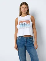 Musculosa blanca con estampado de paisaje desértico en tonos naranja y azul.