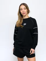 Buzo negro de felpa sin frisa con cuello redondo y logo Umbro bordado en blanco en el pecho. Presenta ribetes blancos en contraste en hombros y mangas.