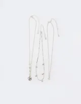 Set de tres collares cortos plateados con dijes de estrellas y constelaciones.