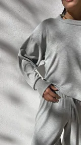 Conjunto deportivo gris de algodón waffle, compuesto por un buzo de corte cropped y un pantalón de corte ancho con cintura elastizada.